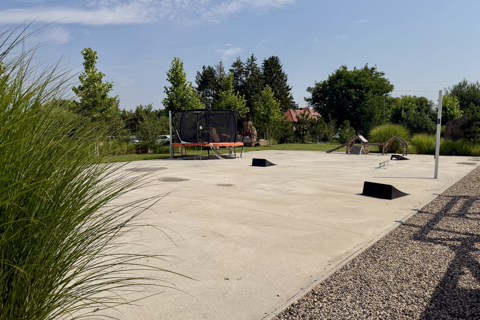 Velká betonová plocha s trampolínou v areálu BÍBÍK